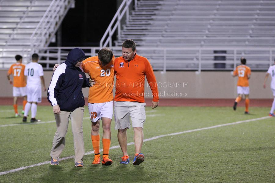 Junior Kirk Riley is helped off the field with a minor head injury.